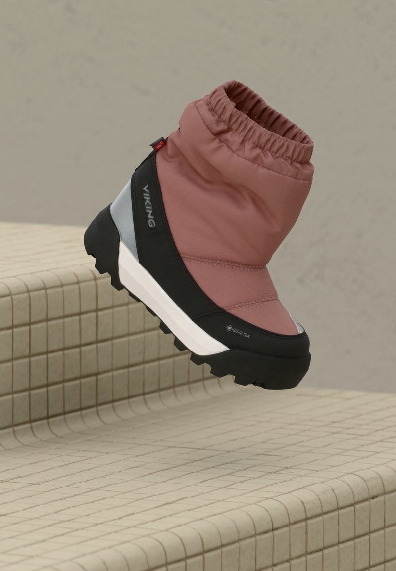 Vandeniui atsparūs rožiniai nailoniniai batai su juodu guma padu, elastinga apykakle ir tekstūruotu protektoriumi. Šone yra GORE-TEX ženklas.