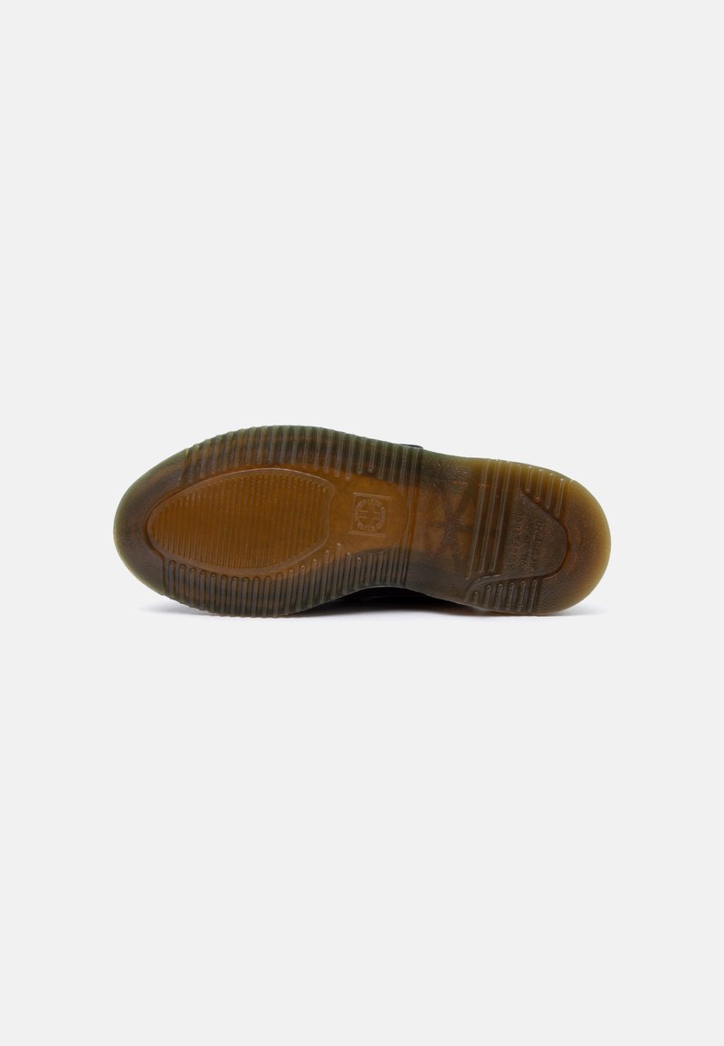 Suola di una scarpa nera con battistrada in gomma marrone traslucida e testurizzata, caratterizzata da creste e motivi antiscivolo su sfondo bianco.