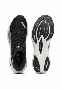 Black athletic shoes with mesh upper, PUMA logo, and white accents. The sole features a textured tread pattern for grip and stability.