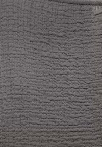 Tissu gris doux avec un motif texturé froissé et légèrement en relief formant des lignes horizontales irrégulières sur la surface.