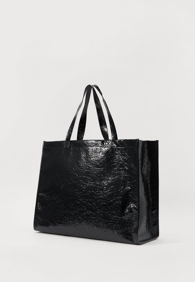 Black tote bag made of shiny, textured material. Features two handles, a rectangular shape, and a subtle logo on the front.