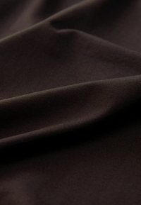 Dark brown fabric with a smooth texture, featuring subtle wrinkles and creases, highlighting its drape and thickness.