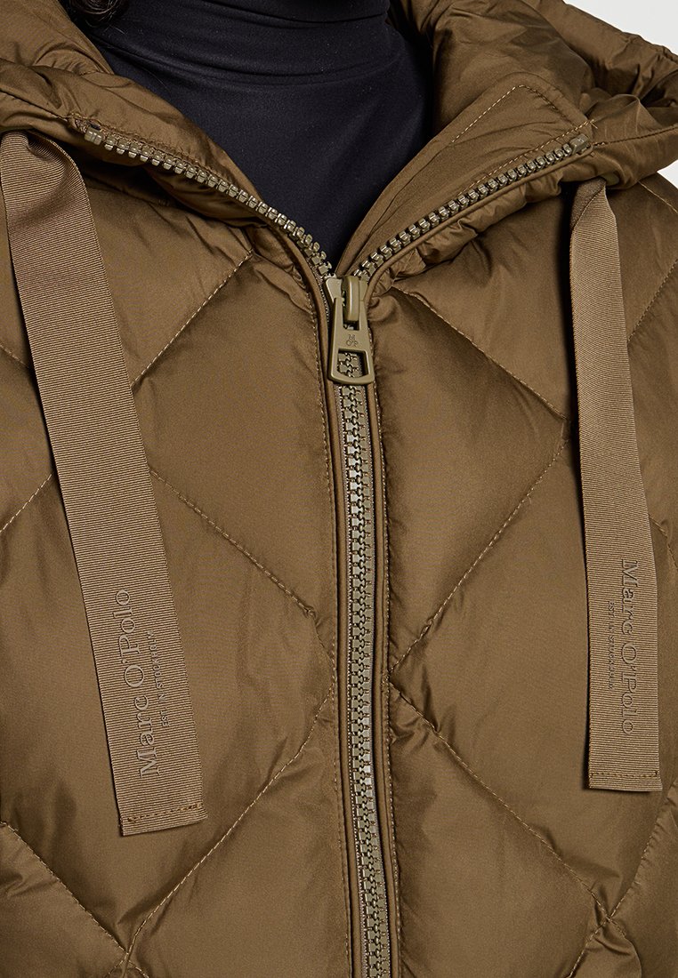 Gequilte bruine jas met een ritssluiting aan de voorkant, verstelbare capuchon en gebrandmerkte stoffen banden op de schouders. Textuurstof met een gladde afwerking.