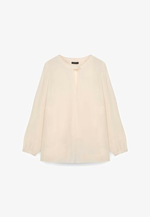 Kremowa bluzka z długim rękawem i okrągłym dekoltem, z detalem typu keyhole z przodu oraz marszczonymi mankietami, wykonana z lekkiego materiału.