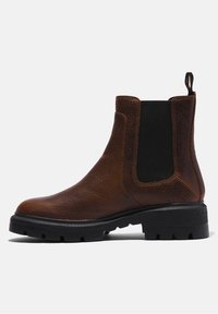 Bottine Chelsea en cuir marron avec panneau latéral élastique noir, semelle noire épaisse et languette à l'arrière.