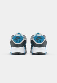 Nike Air sneakers in gray and black, featuring blue accents. Textured fabric on the upper and rubber outsole with traction pattern.