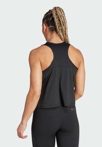 Czarny sportowy top na ramiączkach o luźnym kroju, z tyłem w stylu racerback i zaokrąglonym dołem. Materiał wydaje się gładki z minimalnie widocznymi szwami.
