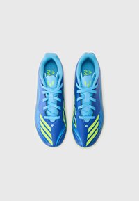 Scarpe da ginnastica blu con materiale liscio, caratterizzate da strisce verde neon e lacci blu. Il design è snello per ottimizzare le prestazioni.