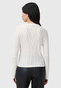 Maglione a maniche lunghe in crema con righe verticali grigie, caratterizzato da una vestibilità aderente e un sottile scollo a barchetta sul retro. Tessuto testurizzato.