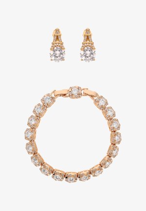 Armband aus Roségold mit runden klaren Steinen. Dazu passende Ohrringe mit runden Steinen, die in ohrsteckerförmigen Eiffeltürmen gefasst sind.