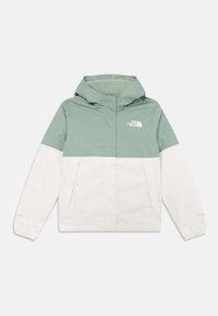 Veste légère en vert et crème, dotée d'une capuche, de poches zippées et d'une doublure douce et texturée. Le logo The North Face est visible sur la poitrine.
