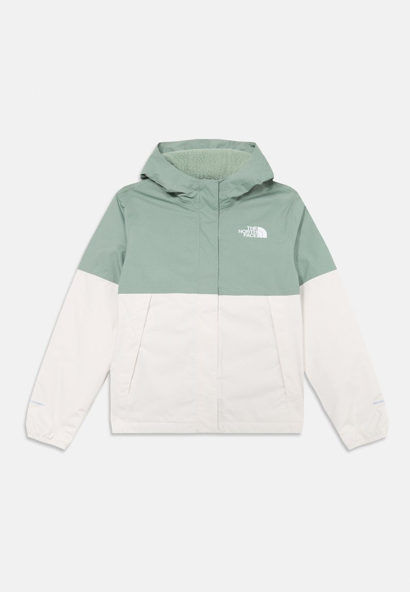 Veste légère en vert et crème, dotée d'une capuche, de poches zippées et d'une doublure douce et texturée. Le logo The North Face est visible sur la poitrine.