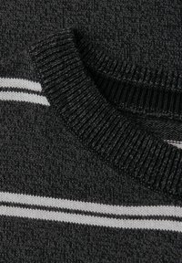 Gebreide trui met een zwarte stof met een textuur en twee witte horizontale strepen op de kraag en het lichaam.