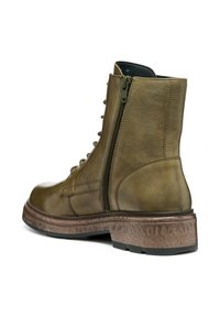Botte de cheville en cuir vert olive avec une semelle texturée brun, fermeture éclair latérale et lacets à l'avant. Présente un bout arrondi et des accents cousus.