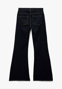 Donkerblauwe flared jeans met een gladde textuur, vijf zakken en contrasterende gele stiksel details op de naden.
