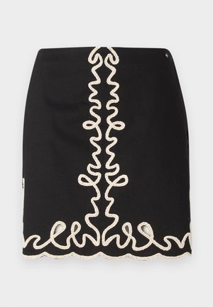 Czarna spódnica z teksturowanym, kremowym haftem w wirujące wzory wzdłuż środka i u dołu.