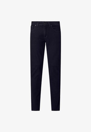 Donkerblauwe jeans met een slim fit, vijf-pocketontwerp en subtiele stikdetails, gecombineerd met zwarte schoenen en een grijs shirt.