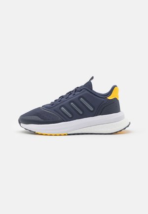 Chaussure de course bleu marine avec semelle blanche et accent jaune sur le talon, dotée d'une tige en mesh texturé et de trois bandes sombres sur le côté.