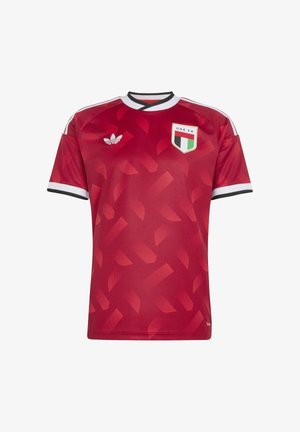 Punainen jalkapallopaita, jossa on valkoiset ja mustat reunukset, UAE:n jalkapalloliiton vaakuna rinnassa, Adidas-logo ja hienovarainen geometrinen kuvio.