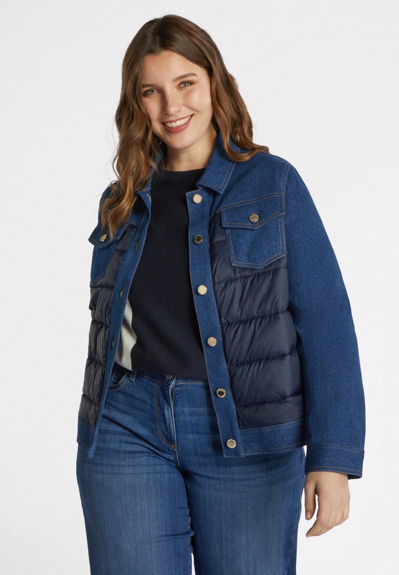Chaqueta de mezclilla y acolchada con tonos azules, que presenta un frente con botones, dos bolsillos en el pecho y texturas en contraste en la tela.