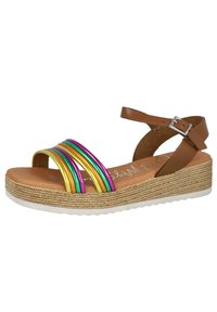 Sandal de tiras marrón con franjas metálicas multicolores (oro, púrpura, verde) en la parte delantera; suela de yute trenzado; cierre con hebilla en el tobillo.