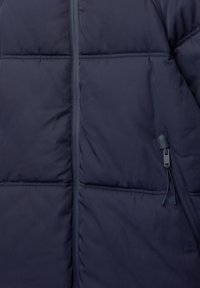 Tengerész kék puff jacket, steppelt részekkel, elöl cipzáras záródással és állítható húzózsinórral. Könnyű anyag puha tapintással.