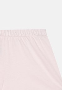 Cintura elástica de color rosa claro, tela de algodón suave. Textura lisa con un ligero fruncido en la cintura. Diseño simple, sin patrones o acentos distintivos.