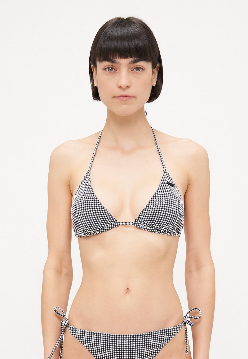Svart og hvit ruter bikini med trekantet topp og justerbare snorer i sidene av trusen. Glatt stoff, minimal maskindetalj.