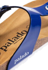 Sandalo blu con infradito, caratterizzato da una fascia larga e lucida e una soletta in sughero con una texture scamosciata marrone, marchiato con "palado" in bianco.