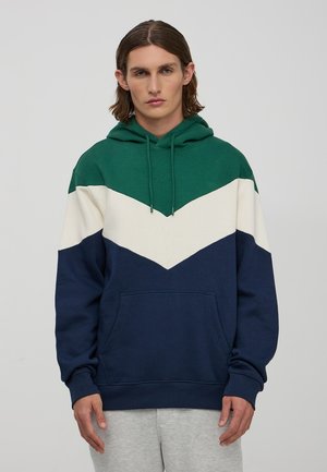 Felpa con cappuccio verde, bianca e blu navy con motivo a zigzag. Realizzata in tessuto morbido, presenta una tasca frontale e un cordino regolabile.