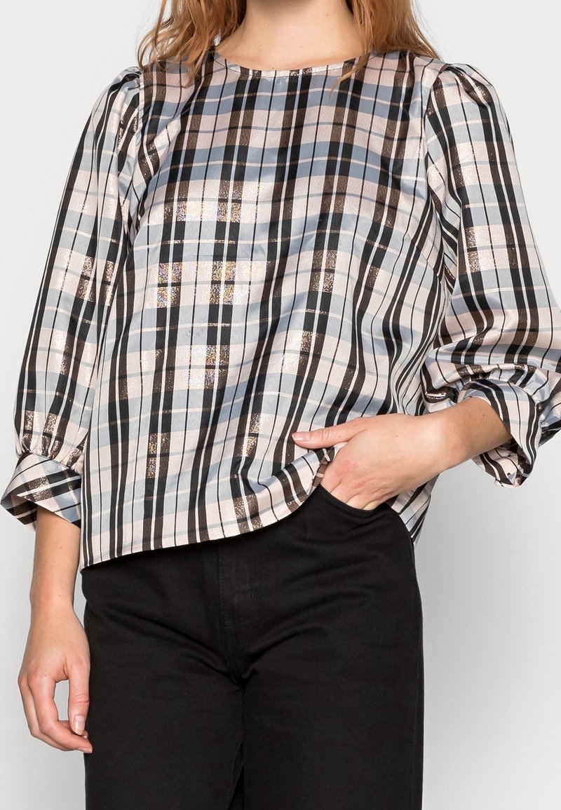 Ljus rutmönstrad blus med puffärmar, med blå, svarta och bronsfärgade ränder på en ljus bakgrund. Slät tyg med rundad halsringning.