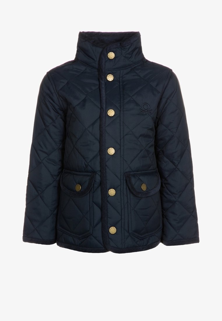 Giacca trapuntata blu navy con colletto alto, bottoni dorati davanti, due tasche a patta con chiusura a bottone dorato e logo discreto sul petto.