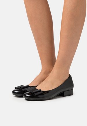 Ballerines en cuir verni noir avec un embout arrondi et un joli nœud noir décoratif à l'avant. Talon bas.