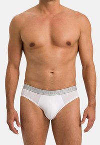 Slip da uomo bianchi con una fascia elastica grigia che presenta il logo 'HANRO', realizzati in tessuto liscio con un design aderente.