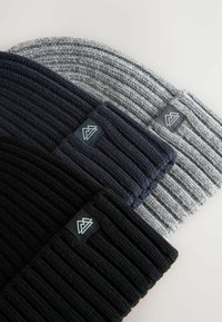 Drie gebreide mutsen in zwart, donker marineblauw en grijs. Elke muts heeft een geribbelde textuur en een klein logo-patch met een bergontwerp.