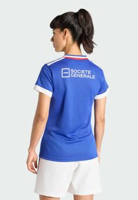 Camiseta deportiva azul con detalles blancos, que presenta un texto de logo "SOCIETE GENERALE" en la parte trasera y un cuello con rayas rojas.