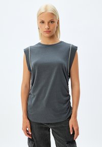 Top grigio senza maniche in tessuto morbido, con scollatura tonda e dettaglio arricciato sul lato, accentuato da una cucitura sottile lungo la spalla.