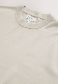 Maglione beige chiaro con scollo rotondo e collo a coste, taglia media etichettata della collezione N. Premium, disteso su uno sfondo neutro.
