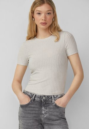 T-shirt à rayures gris clair avec des manches courtes, un col rond, et une silhouette ajustée, associé à un jean gris délavé.