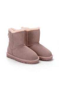 Botas de tobillo de ante rosa con un suave forro de piel de oveja de color rosa claro, suela de goma plana y costuras a lo largo de los costados. Diseño de parte trasera cerrada.