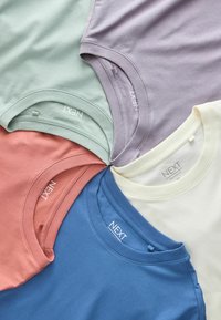 Viis voltidega ümara kaelusega t-särki pastelsinises, lavendli, koore, sinise ja korallikarva toonides, paigutatud ringikujulisse mustrisse.