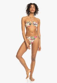 Bloemen bikini set met een bandeau-top met een centrale sleuf en verstelbare strikjes. Kleuren zijn roze, groen en beige met een gladde textuur.