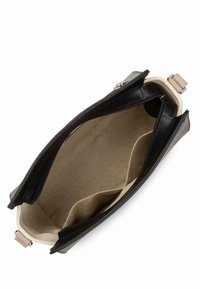 Zwarte leren handtas interieur met een beige voering, voorzien van twee ritscompartimenten en meerdere zakken. Gladde textuur en gestroomlijnd ontwerp.