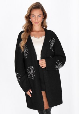 Schwarze Strickjacke mit langen Ärmeln, aus strukturiertem Stoff und mit floralen Verzierungen. Das offene Design vorne passt gut zu geschichteten Styles.