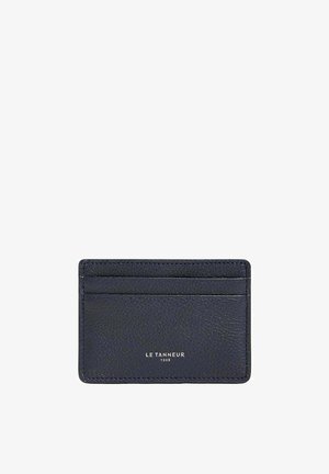 Porte-cartes en cuir marine avec finition texturée, quatre emplacements et logo en relief. Forme rectangulaire compacte, design minimaliste.