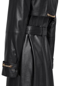 Zwarte leren trenchcoat met een ceintuur in de taille, voorzien van gouden kettingaccenten op de manchetten en een gladde, glanzende textuur.