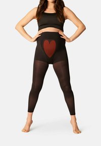 Zwarte zwangerschapsleggings met een hoge taille, voorzien van een groot rood hartontwerp aan de voorkant. Gladde textuur en aansluitende silhouet.