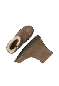 Botines de ante marrón con un suave forro color crema y una suela de goma texturizada, que cuentan con una cremallera lateral para un fácil acceso.