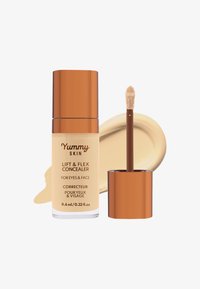 Korektor Lift & Flex w oszklanym słoiczku z efektem frosted i złotą nakrętką, obok beżowego swatcha i aplikatora typu doe-foot. 9,4 ml.