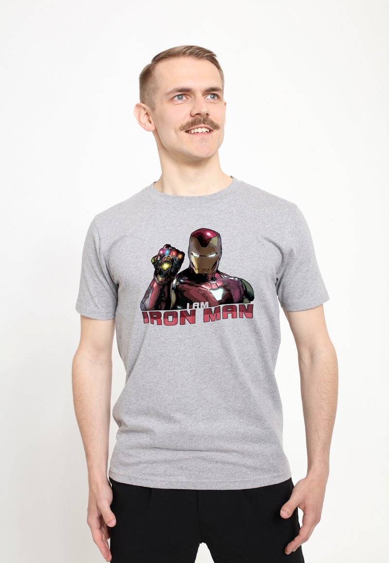 Camiseta de algodón gris que presenta un gráfico de Iron Man con la mano levantada y el texto "SOY IRON MAN". Diseño de mangas cortas, cuello redondo y corte casual.